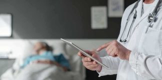 Rushed Euthanasia After Suicide Hold? Doctor using tablet beside hospital patient