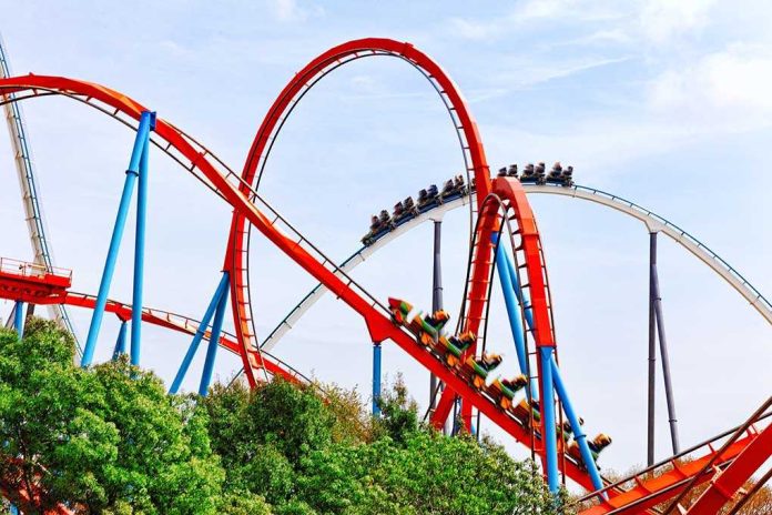 shutterstock_232504156 Colorful roller coaster with riders on a sunny day