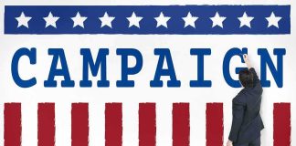 $64M Shock Upends Texas Race Man in suit writing on large campaign banner with stars and stripes
