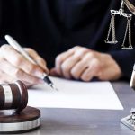 Judge Advances Chilling Terror Threat Case Judge writing at desk with gavel and Lady Justice statue